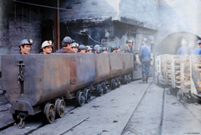 Mineros entrando a la mina en los vagones de carbón