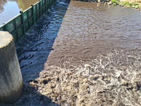 Agua turbia con lodos en la playa fluvial de La Ribera de Folgoso, en el río Boeza.